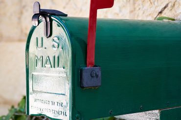 Green US Mail box with red flag up